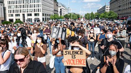 Teilnehmer einer Demonstration unter dem Motto ´Black lives still matter» stehen mit Schildern mit der Aufschrift ´BLM» und ´Silence is Violence» auf dem Pariser Platz. 