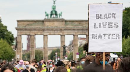 Teilnehmer der ´Black Lives Matter»-Demonstration ziehen mit einem Schild durch Berlin.