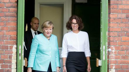 Bundeskanzlerin Angela Merkel (CDU) kommt aus einem Treppenhaus der Ferdinand-Freiligrath-Schule im Stadtteil Kreuzberg zusammen mit der Direktorin Anke Schmidt. 