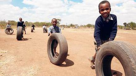  In der „Juja Farm“, der Einrichtung für ältere Waisenkinder von "Happy Life Children's Home" spielen Jungs mit Reifen. Alle schätzen es, in die Schule auf dem Areal außerhalb Nairobis gehen zu können. Einige Häuser auf dem Gelände sind noch im Bau befindlich, es mangelt noch an Geld.