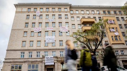 Plakate gegen den Verkauf von Mietwohnungen an die Deutsche Wohnen hängen an einer Gebäudefassade in der Karl-Marx-Allee.