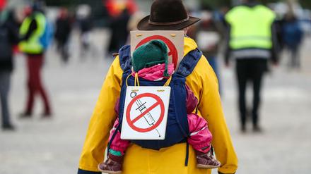 Eine Teilnehmerin einer Protestkundgebung der Initiative "Querdenken" trägt ein Schild gegen Impfungen.