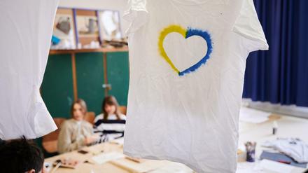 Ein T-Shirt mit einem Herz, umrahmt von den ukrainischen Farben hängt im Klassenraum einer Willkommensklasse am Willy-Graf-Gymnasium in Berlin-Lichterfelde.