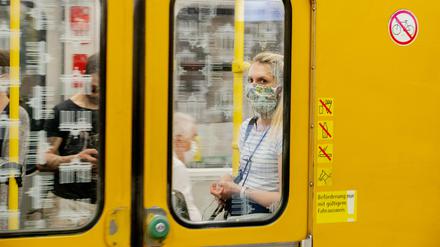 Eine Frau mit Mundschutz in einer Berliner U-Bahn. 