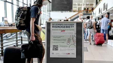 Schilder weisen auf die Corona-Teststelle am Flughafen Schönefeld hin. 