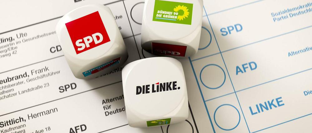 Stimmzettel zur Bundestagswahl. Darauf liegen Würfel in den Farben der rot-rot-grünen Koalition