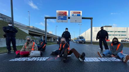  Klimaschutz-Aktivisten der Initiative "Aufstand der letzten Generation" blockieren eine Zufahrt zum Hauptstadt-Flughafen BER.