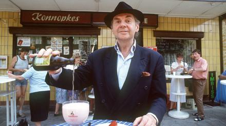 Schauspieler Harald Juhnke, aufgenommen 1991 vor Konnopke's Imbiß in der Weißenseer Mahlerstraße mit Currywurst und einem Glas Berliner Weiße.