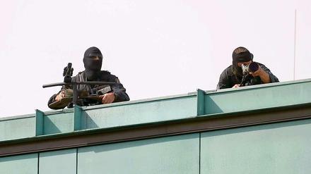 Scharfschützen der Polizei sichern auf Dächern den Staatsbesuch ab.
