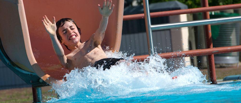 Ein Kind rutscht im Prinzenbad ins Wasser.