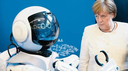 Skeptisch beäugt Angela Merkel die digitale Zukunft, einen „Pflegeroboter“. 
