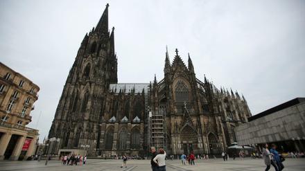 Touristen stehen vor dem Dom in Köln