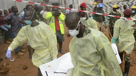 Sicherheitskräfte bergen am in Regent (Sierra Leone) einen Toten. 