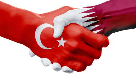 Eine Hand wäscht die andere, sagt ein Sprichwort. Diese beiden zeigen die Flaggen der Türkei und Katars.