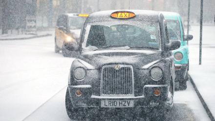 Ein Taxi fährt vergangenen Februar auf einer schneebedeckten Straße in London. 