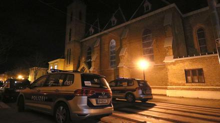 Polizeiautos stehen vor der überfallenen Kirche bei Wien