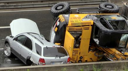 Ein Bagger liegt am Montag auf der Autobahn 40 bei Bochum auf einem PKW. Bei dem spektakulären Unfall ist ein Autofahrer bei Bochum nur knapp mit dem Leben davon gekommen.