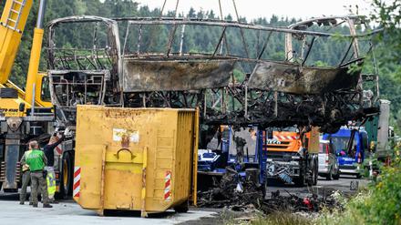 Das Wrack eines nach einer Kollision mit einem Lkw völlig ausgebrannten Reisebusses wird an der Unglücksstelle auf der Autobahn 9 bei Münchberg geborgen.