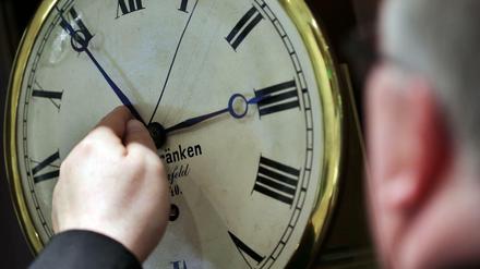 Ein Uhrenhändler stellt eine Uhr von zwei auf drei Uhr vor. 