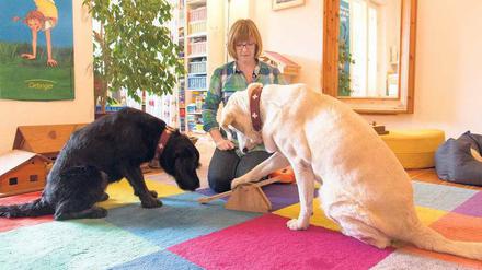 Spielen und üben. Die Logopädin Carola Schneider-Tobis mit ihren Therapiehunden Annuk (schwarzes Fell) und Clea. 