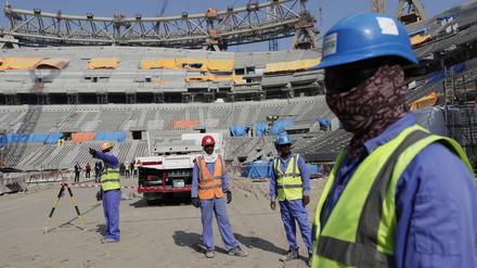 Bauarbeiter arbeiten am Lusail-Stadion, einem der Stadien der WM 2022. 