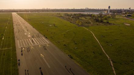 Menschen sind während des Sonnenuntergangs auf dem Tempelhofer Feld unterwegs, Symbolbild.