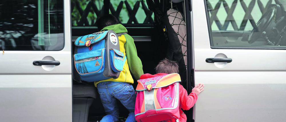 Brandenburg, Potsdam: Schulkinder steigen in ein privates Fahrzeug. 