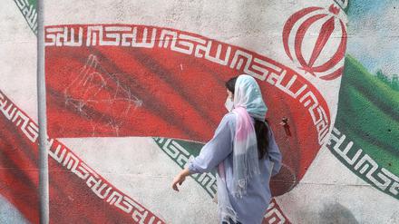 Eine iranische Frau läuft auf der Straße.