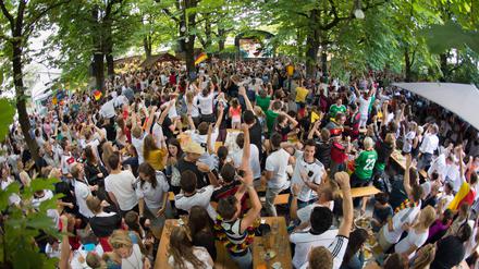 Fußballfans jubeln in einem Münchner Biergarten während eines Spiels der deutschen Nationalmannschaft 2014. 