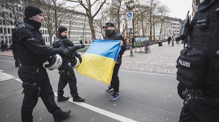 Bei einer pro-russischen Demo diskutiert ein Unterstützer der Ukraine mit Polizisten in Köln im April 2024.