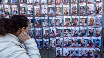Eine Frau schaut auf Poster der von der Hamas entführten Geiseln.