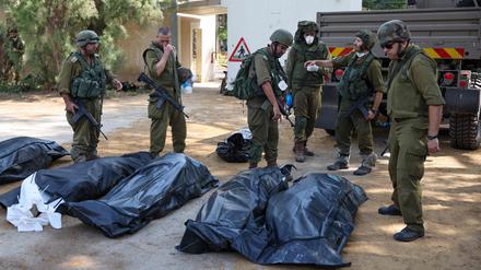 Soldaten bergen die Leichen von getöteten israelischen Zivillisten. 