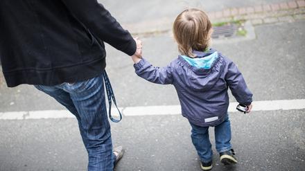 Eine Mutter hält ihren Sohn an der Hand. Mehr als jedes fünfte Kind und jeder vierte junge Erwachsene in Deutschland sind einer Studie zufolge armutsgefährdet.