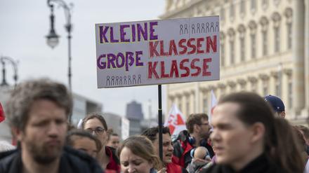 Lehrkräfte nehmen an einem Warnstreik in Berlin teil und halten ein Plakat mit der Aufschrift „Kleine Klassen - große Klasse“ hoch. 