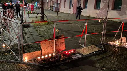 Brennende Kerzen stehen vor Schildern mit der Aufschrift «Stop Antisemitismus» an dem abgesperrten Bürgersteig vor dem jüdischen Gemeindezentrum an der Brunnenstraße nach dem versuchten Brandanschlag in der Nacht zum 18. Oktober 2023 auf die Synagoge in dem Gebäudekomplex.