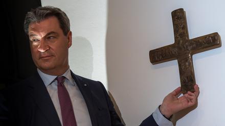 Markus Söder (CSU), bayerischer Ministerpräsident, hängt ein Kreuz im Eingangsbereich der bayerischen Staatskanzlei auf. (Archivbild von 2018)