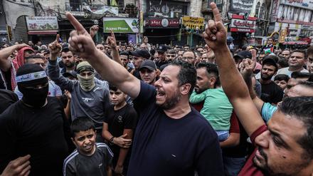 Palästinenser gestikulieren und skandieren Slogans während einer Demonstration gegen Israel im Westjordanland.