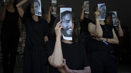 Angehörige und Unterstützer von israelischen Geiseln halten Fotos ihrer Angehörigen bei einer Kundgebung in Tel Aviv.