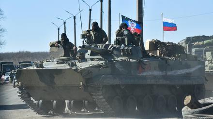 Militärfahrzeuge zeigen Flaggen der Volksrepublik Donezk und Russlands auf der Straße zwischen Volnovakha und Dokuchayevsk.