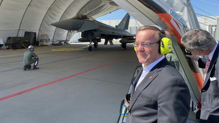 Boris Pistorius (M., SPD), Bundesverteidigungsminister, steht neben einem Hangar mit einem Eurofighter der Luftwaffe. 