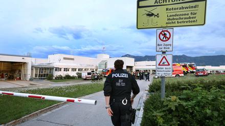 Polizisten und Einsatzkräfte der Feuerwehr stehen vor der abgeriegelten Notaufnahme des Unfallklinikums Murnau.