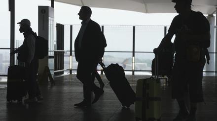 Passagiere gehen mit ihrem Gepäck durch den Flughafen Heathrow in London. 