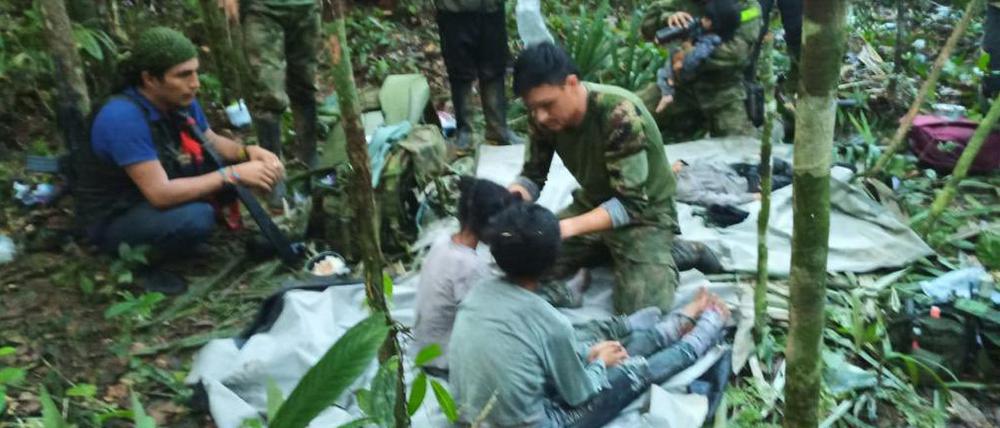 Auf diesem von der Pressestelle der kolumbianischen Streitkräfte veröffentlichten Foto kümmern sich Soldaten und indigene Männer um die vier Geschwister, die nach einem tödlichen Flugzeugabsturz vermisst wurden.