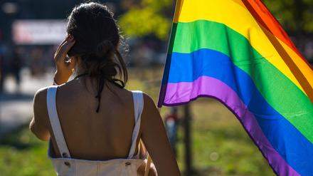 Eine Frau hält eine Regenbogenfahne.  