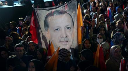 Anhänger des türkischen Präsidenten Recep Tayyip Erdogan halten nach Schließung der Wahllokale ein Plakat mit seinem Konterfrei vor der AKPO-Zentrale in die Höhe.