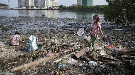 Freiwillige sammeln in einem verschmutzten Küstengebiet Müll auf (Archivbild).