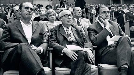 Engagement im öffentlichen Raum. Der Schriftsteller Heinrich Böll, der Philosoph Theodor W. Adorno und Suhrkamp-Verleger Siegfried Unseld (v.l.) unterstützen den Protest gegen die Notstandsgesetze. Eine Veranstaltung im Großen Sendesaal des Hessischen Rundfunks in Frankfurt am Main am 28. Mai 1968. 