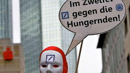 Ein Demonstrant protestiert vor dem Gebäude der Deutschen Bank in Frankfurt gegen die Entscheidung des Unternehmens, weiterhin mit Agrarrohstoffen zu spekulieren.