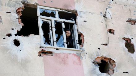 Ein Mann blickt aus einem Gebäude in Diyarbakir, das bei Kämpfen zwischen türkischen Sicherheitskräften und militanten Kurden stark beschädigt worden ist. 