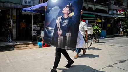 Ein Protestierender mit einem großen Plakat, das die bisherige De-facto-Regierungschefin Aung San Suu Kyi zeigt. 